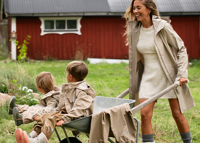 Nainen työntää kärryä, jossa on kaksi lasta, tekstillä 'Kenza X Viking'.