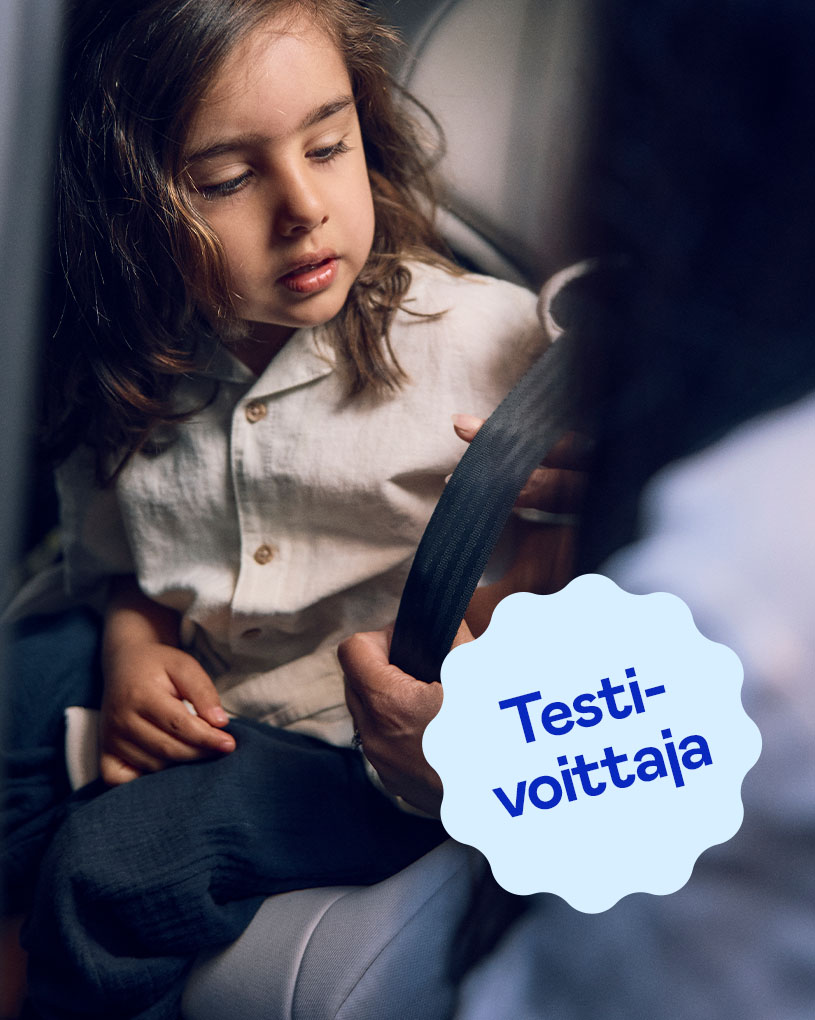 Hymyilevä lapsi turvaistuimessa ja teksti 'Testivoittajat'.