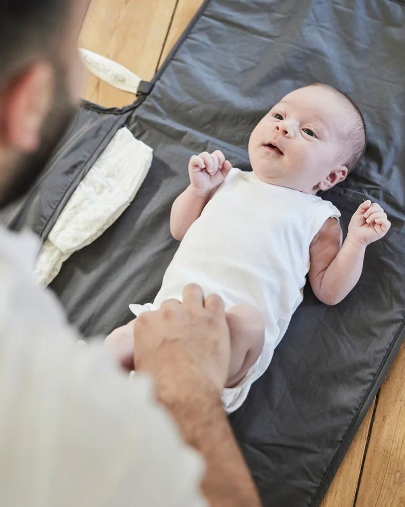 Harmaa lastenvaunu, jonka kahvassa on harmaa säilytyspussi.