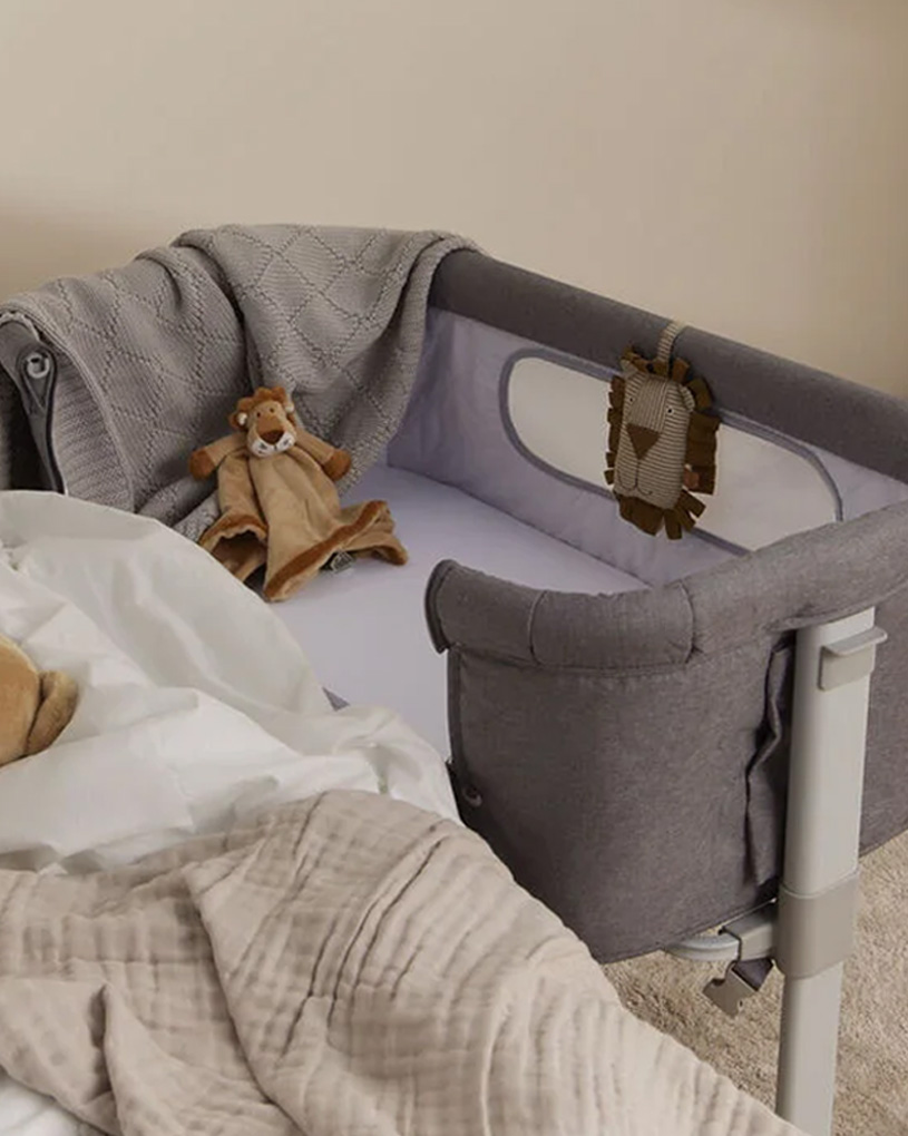 Harmaa sivusänky, pehmolelu ja peitto lastenhuoneessa.