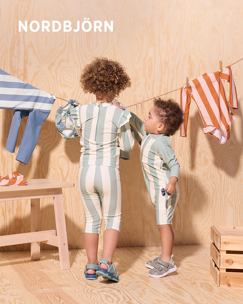 Lapsi auringonhatussa leikkii ämpäreillä puuterassilla.