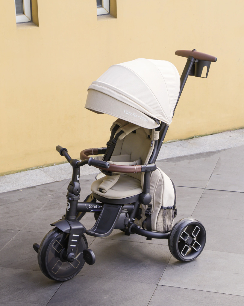 Beige kolmipyörä aurinkosuojalla keltaista seinää vasten.